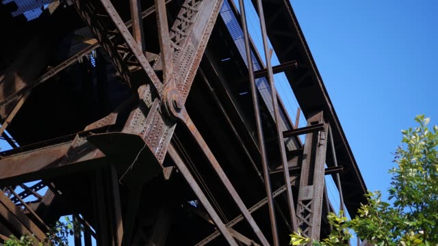 An-establishing-shot-of-a-rusty-steel-railroad-overpass