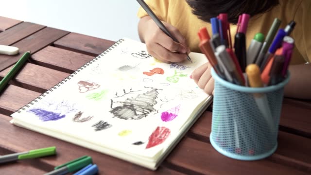Children-homework-close-up.-Young-mixed-race-boy-doing-homework-in-terrace-at-home.-Drawing-and-writing.-Focus-mood.-Back-to-school-concept.