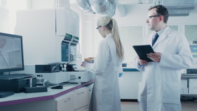 Equipo-de-investigadores-trabaja-en-el-laboratorio-farmacéutico,-usan-médico-moderno-equipo,-computadoras,-análisis-de-sangre-y-muestras-de-Material-genéticas.