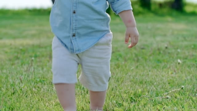 Niedlichen-Kleinkind-zu-Fuß-auf-dem-Rasen
