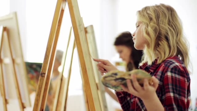 estudiantes-con-caballetes-de-pintura-en-la-escuela-de-arte