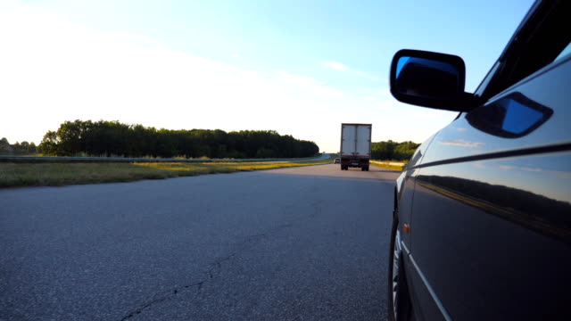 Black-car-driving-on-road-in-the-countryside.-Beautiful-landscape-is-reflected-on-the-auto-door.-Traffic-in-rural-areas.-Point-of-view-Slow-motion