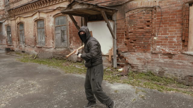 Violent-bandit-training-with-baseball-bat-making-kick-to-camera