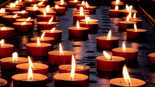 Many-candles-burn-in-dark.-Closeup-view