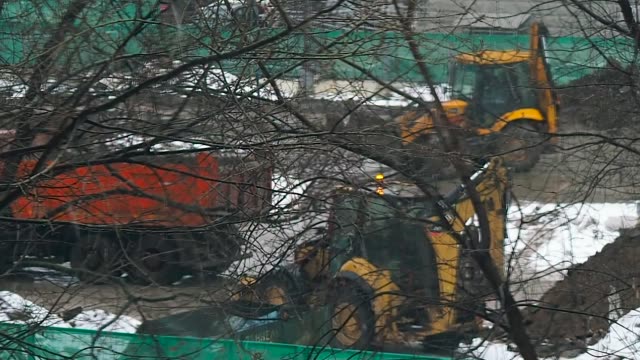 tractor-se-carga-de-camiones-en-el-sitio-de-construcción-en-el-invierno