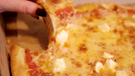 Very-cheesy-pizza-slice-in-hand
