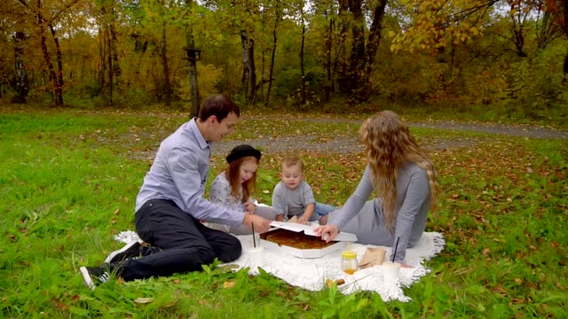 familia-en-otoño-Parque-comiendo-pizza-en-el-césped