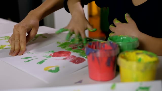 Mädchen-mit-Händen-in-Farben-Fingermalerei-Klasse