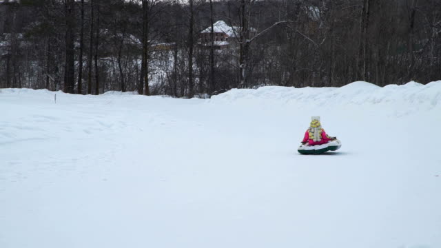 Kleines-Mädchen-reitet-auf-einem-Rodeln-Snowtubing-in-Sibirien