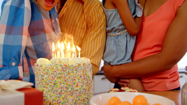 Mid-section-of-black-family-celebrating-birthday-in-kitchen-of-comfortable-home-4k