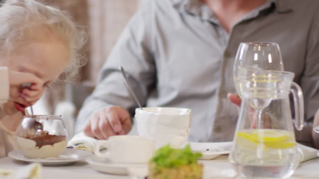 Little-Girl-and-Parents-Eating-in-Restaurant
