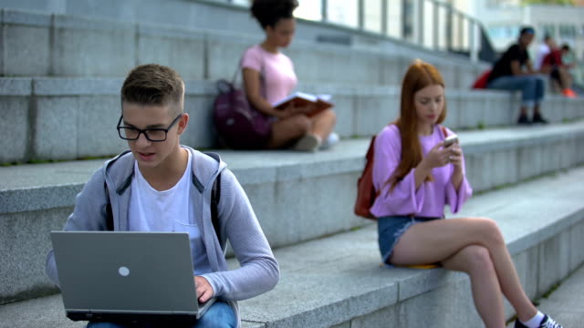 Konzentrierte-High-School-Schüler-arbeiten-Online-Projekt-Laptop,-Spiel