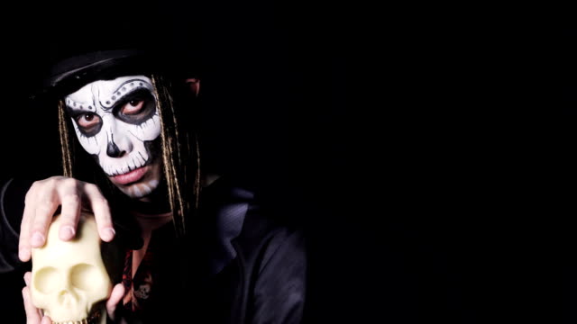 Portrait-of-man-in-witcher-costume-for-Halloween-stroking-skull-in-his-hands
