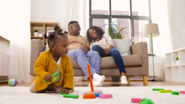 afrikanische-Baby-Mädchen-spielen-mit-Spielzeug-Blöcke-zu-Hause