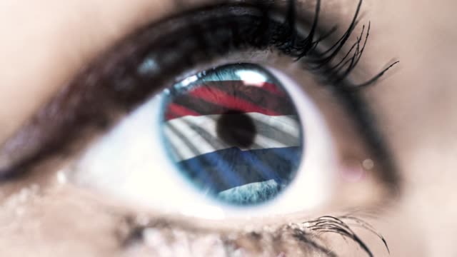 mujer-ojo-azul-en-primer-plano-con-la-bandera-de-los-Países-Bajos-en-el-iris-con-el-movimiento-del-viento.-concepto-de-vídeo