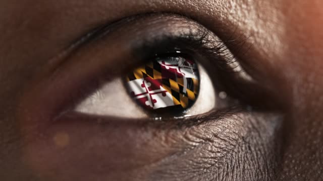Frau-schwarzes-Auge-in-Nahaufnahme-mit-der-Flagge-von-Maryland-Staat-in-Iris,-vereinigte-Staaten-von-Amerika-mit-Windbewegung.-Videokonzept