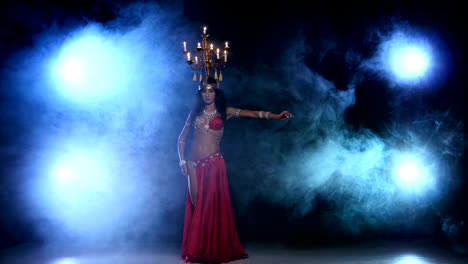 Attractive-belly-dancer-dancing-with-candles-on-her-head,-black,-smoke
