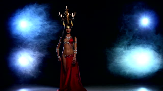 Attractive-belly-dancer-go-on-dancing-with-candles,-her-head,-black,-smoke