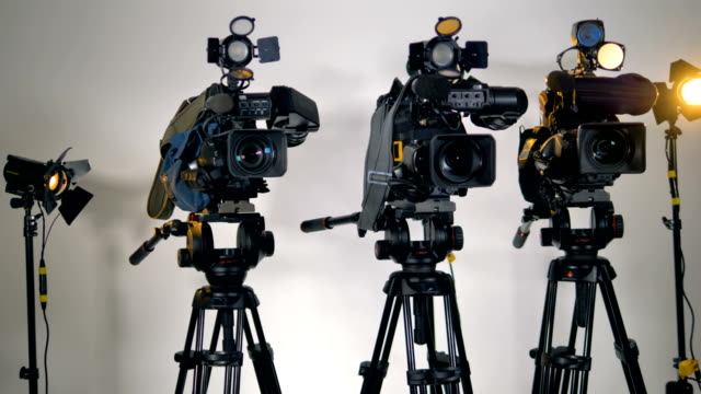 Eine-Reihe-von-mehreren-professionellen-Kameras-auf-Stativen.