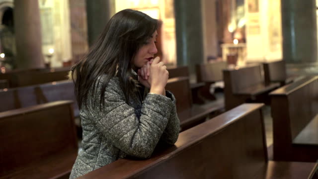 religiöse-Mädchen-beten,-kniend-in-der-Kirche