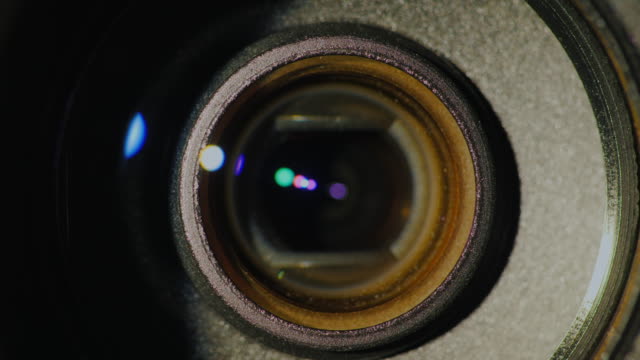 A-close-up-of-the-lens-of-a-video-camera.-The-light-source-illuminates-the-lenses,-then-goes-into-darkness