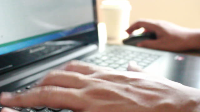 businessman-typing-on-a-laptop-keyboard-in-blurred-focus