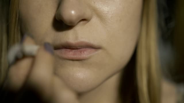Extreme-close-up-of-woman-smoking-cannabis-joint