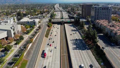 Aerial-Shot-Ascending-Quickly-Over-the-210-Freeway-to-Reveal-Many-Homes,-a-Gas-Station,-Mountains,-Buildings,-and-a-Church-at-Pasadena,-California