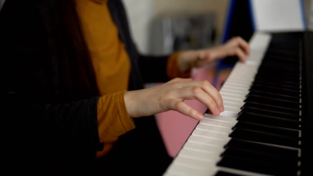 Hände-der-Frauen-spielen-auf-dem-elektronischen-synthesizer