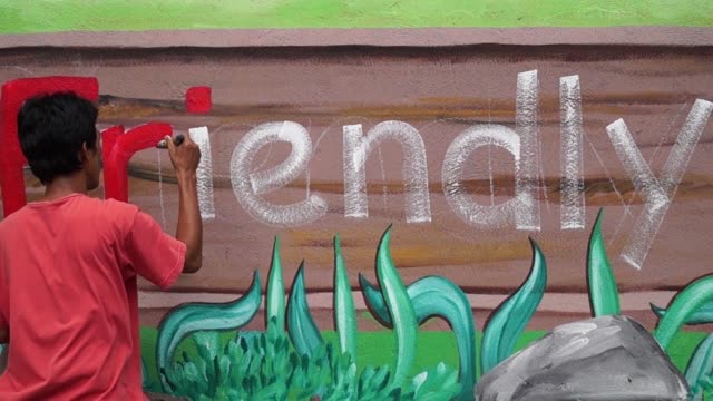 Mural-painter-draws-a-letter-i-on-school-wall.-time-lapse