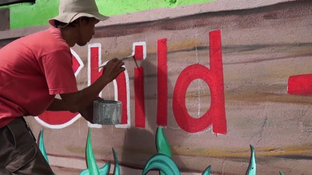Pintor-mural-dibuja-una-letra-en-la-pared-de-la-escuela.-lapso-de-tiempo