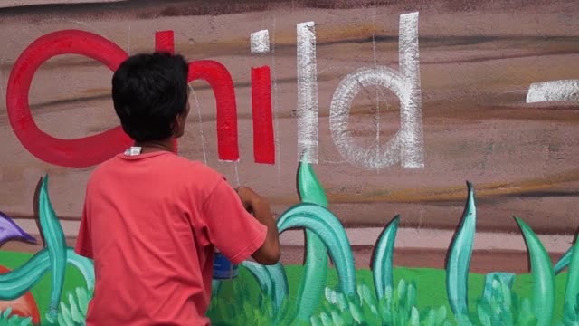 Mural-painter-draws-letter-i-on-school-wall.-time-lapse