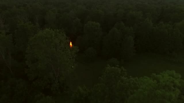 Luftaufnahme-des-ein-Lagerfeuer-im-Wald-bei-Sonnenuntergang-in-Estland.