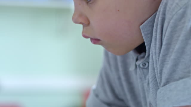 Bored-Schoolboy-Using-Computer-Touchscreen