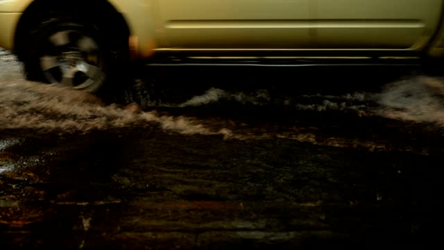 Calle-de-inundación-en-la-lluvia-de-la-noche-caen-con-motos-y-coches-como-fondo