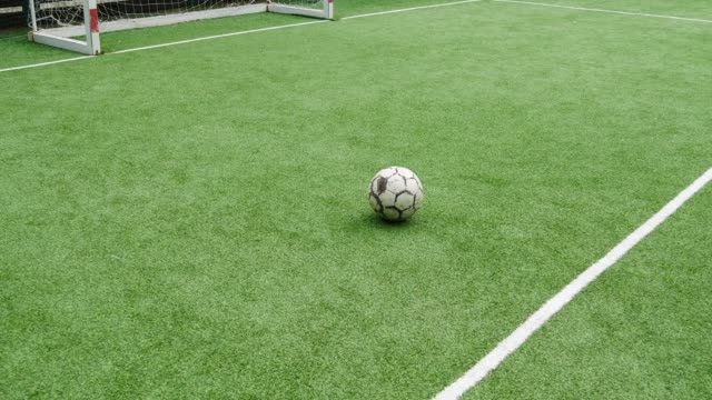 A-soccer-ball-on-an-artificial-lawn-in-front-of-the-goalpost