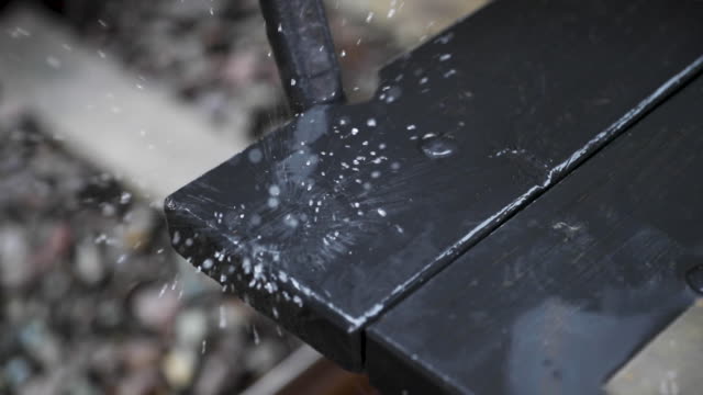 Strong-rain-dripping-down-the-steps-of-an-old-wooden-historic-train-from-1920,-captured-in-slow-motion.
