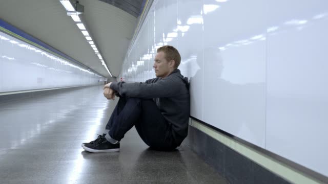 Miserable-jobless-young-man-crying-Drug-addict-Homeless-in-depression-stress-sitting-on-ground-street-subway-tunnel-looking-desperate-leaning-on-wall-alone-in-Mental-disorder-Emotional-pain-Sadness.