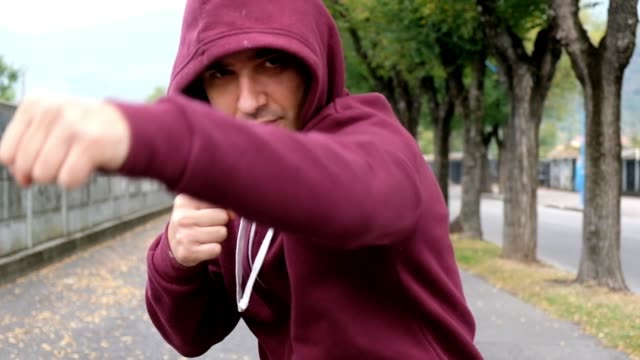 Man-fighting-and-punching-in-city-street