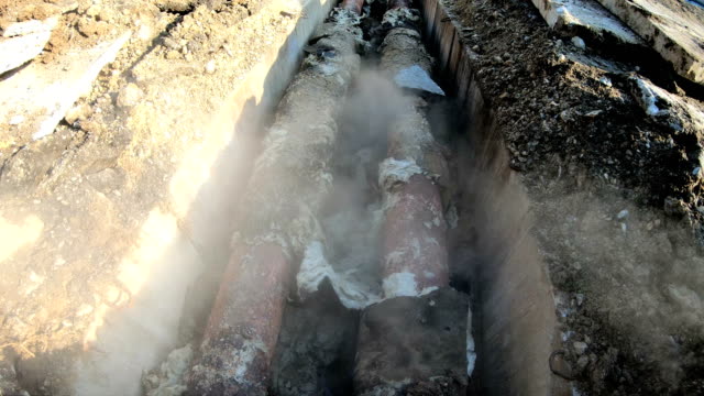 Fernwärme-Pipeline-in-der-Straße-Graben-mit-Warmwasser-undicht-beschädigt