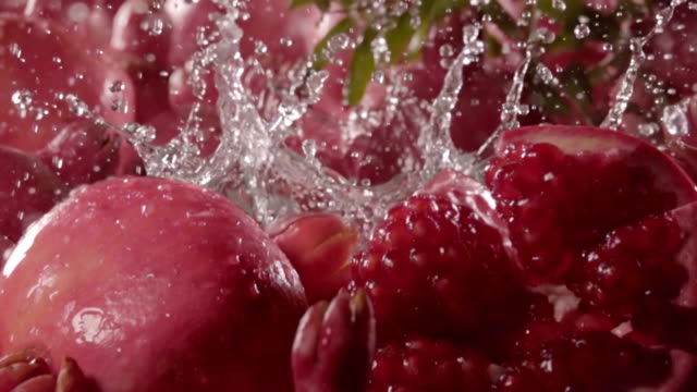 Pomegranate-falling-in-water-with-splash-between-pomegranate.-Slow-motion
