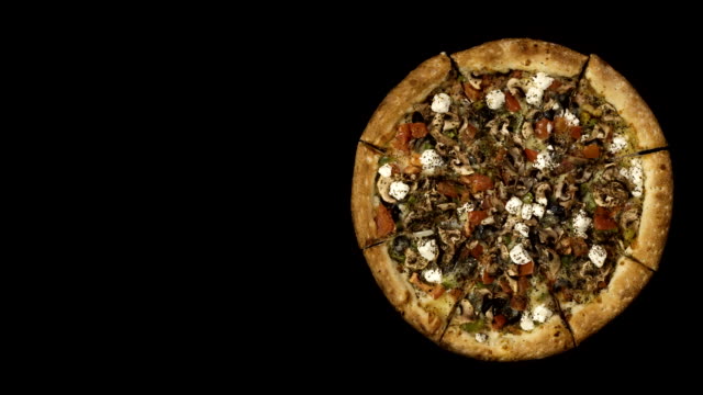 Rotating-pizza-with-smoked-sausage-and-olives-on-a-black-background.-Top-view-center-orientation