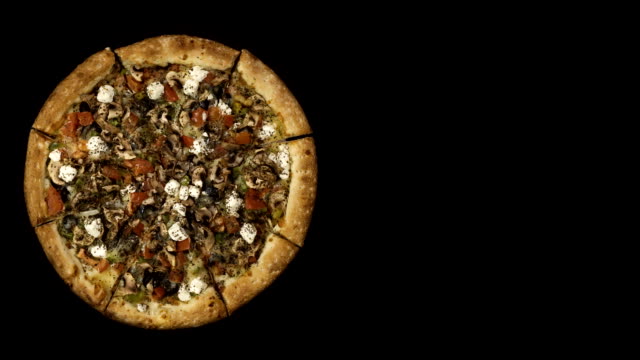 Pizza-con-salchicha-ahumada-y-aceitunas-sobre-un-fondo-negro-en-rotación.-Vista-superior-centro-orientación