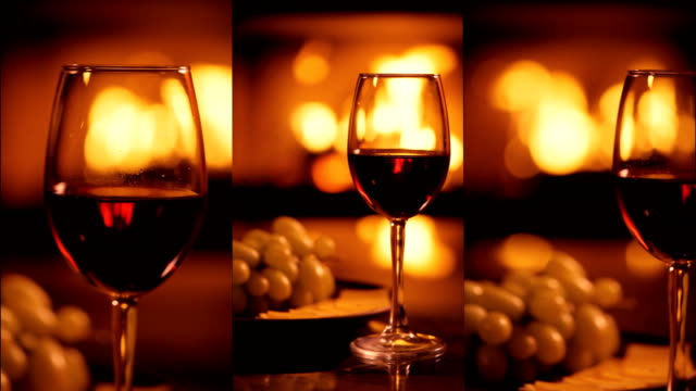 Vertical-videos-of-one-red-wine-wineglasses-over-fireplace-background.