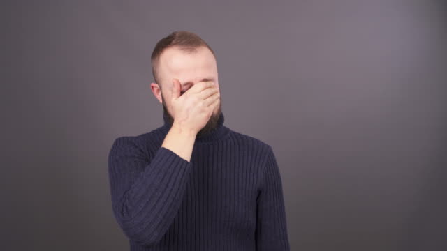 Portrait-of-a-young-crying-man.-Isolated-on-grey-background.