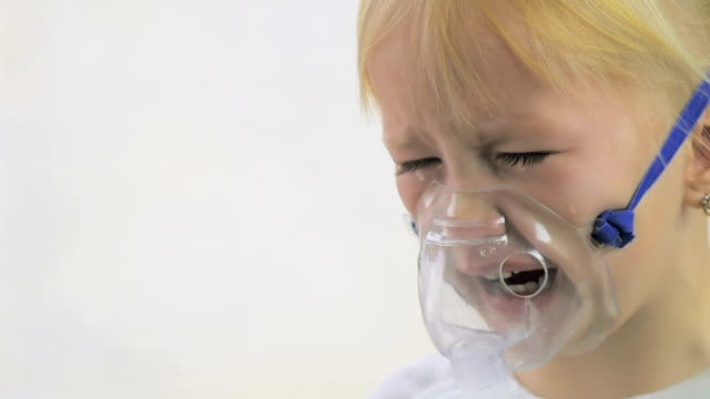Four-year-old-girl-doing-breathing-procedures-through-an-inhaler-mask-in-a-hospital-in-slow-motion.