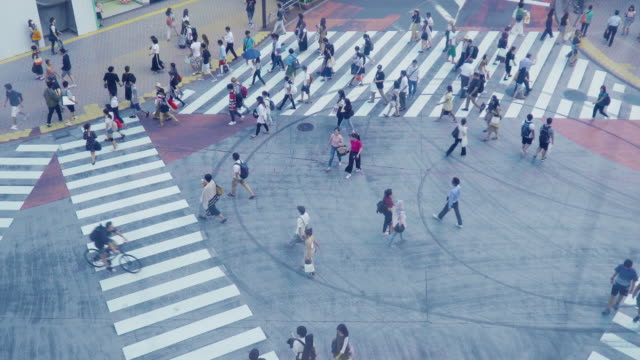 Aerial-view-of-a-crowd-of-pedestrian-crossing-a-big-street-in-Tokyo,-Japan.-The-shot-is-taken-from-an-elevator.