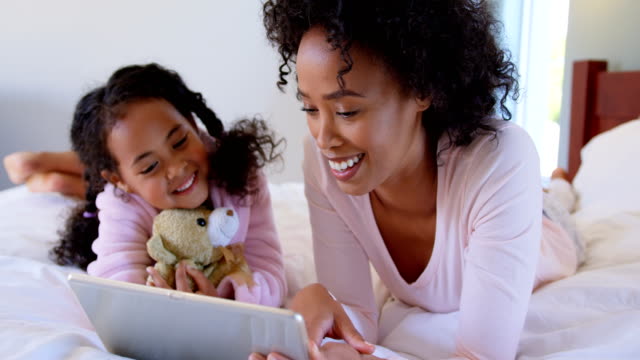 Vorderansicht-des-Schwarzen-Mutter-und-Tochter-mit-digital-Tablette-mit-komfortablen-Zuhause-4k