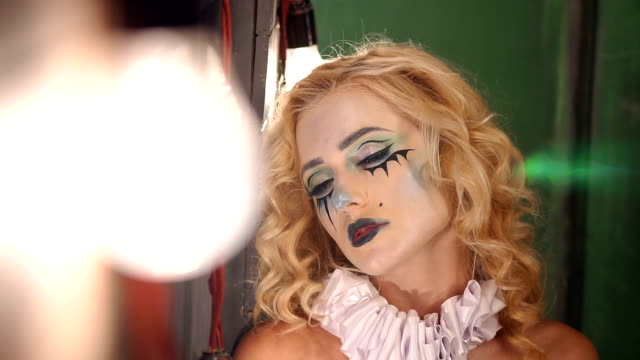 Geheimnisvolles-Mädchen-mit-Make-up-für-Halloween-steht-in-der-Nähe-der-alten-Holzfenster