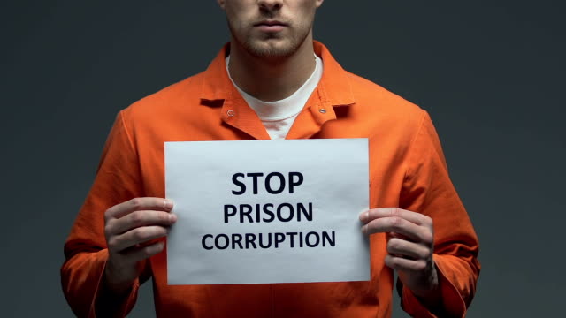Stoppt-Gefängniskorruptionsphrase-auf-Pappe-in-den-Händen-von-kaukasischen-Gefangenen